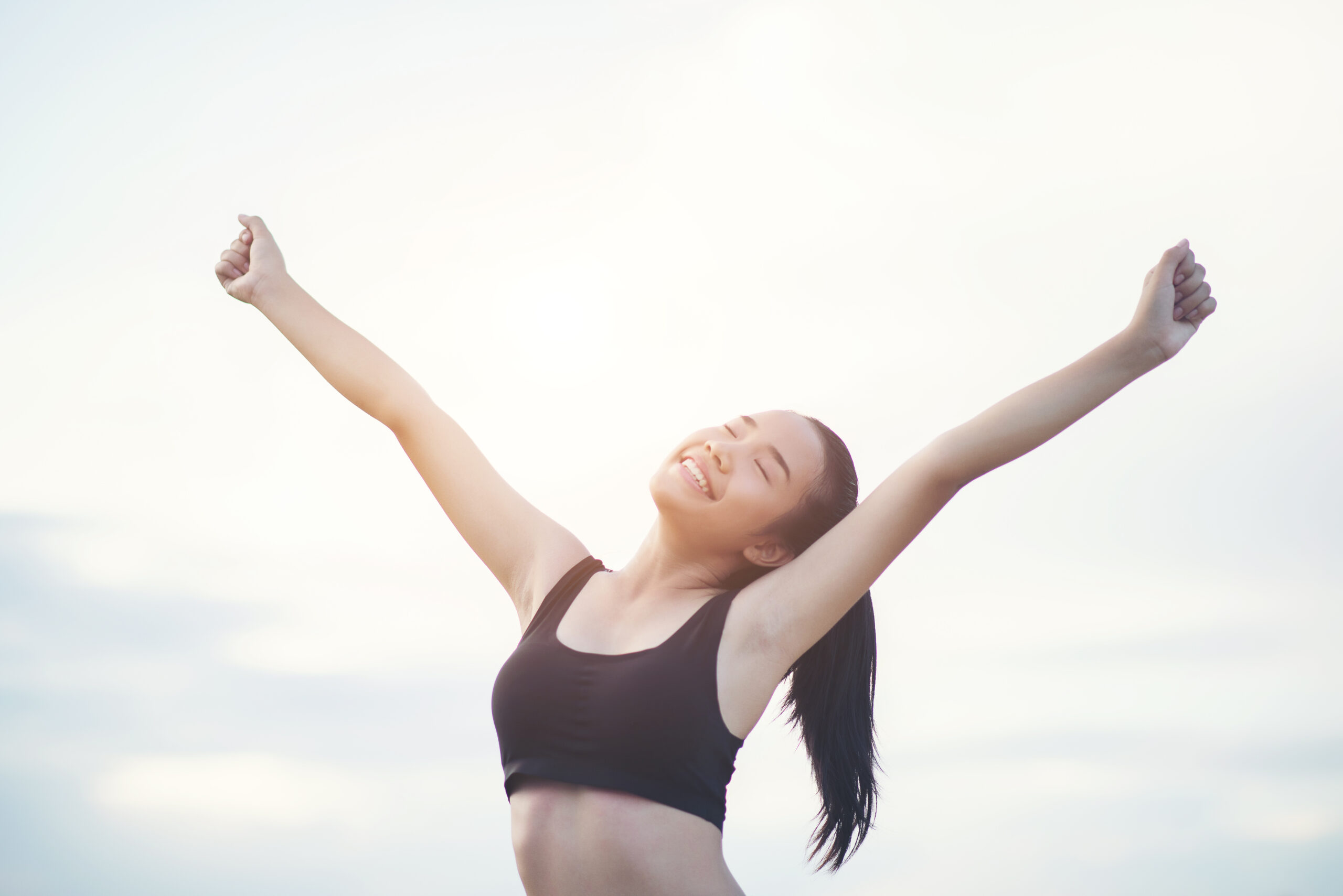 happy smiling athletic woman with arms outstretched scaled